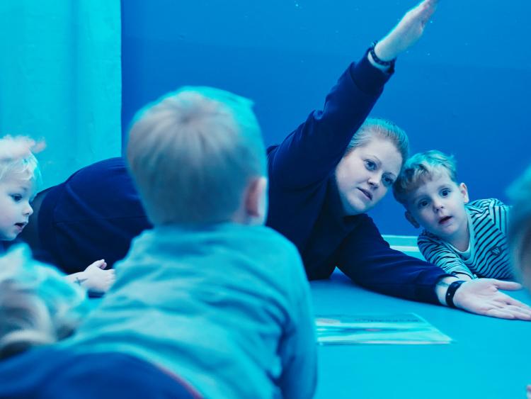 Pædagog laver yoga i et rum med blåt lys