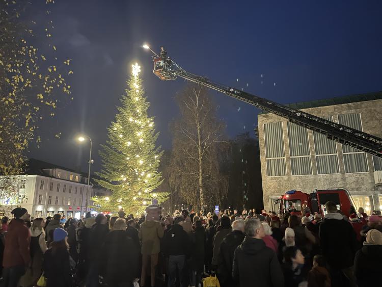 Juletræstænding foran rådhuset i Holte. Der er mange mennesker samlet på pladsen.