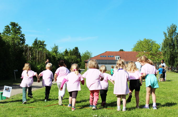 Børn i lyserøde trøjer løber