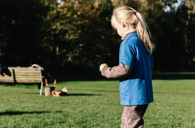 Barn balancerer med bold på ske