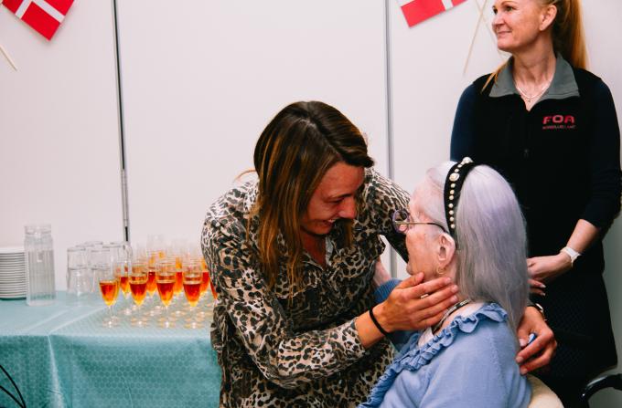 Mette Sander Andersen der giver et kram til en beboer